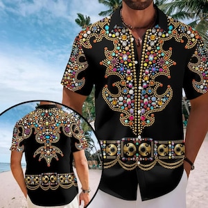 Könnte beinhalten: Ein schwarzes kurzärmeliges Hemd mit Knopfleiste und einem bunten Grafikdruck aus verzierten, juwelenbesetzten Mustern und goldenen Kettendetails. Das Design enthält kreisförmige Edelsteine in Blau-, Rot-, Gelb- und Weißtönen.