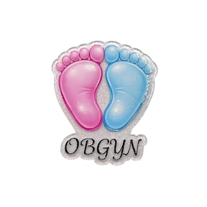 May include: A baby shower decoration featuring a pink and a blue footprint, symbolizing a baby's arrival. The footprints are set against a glittery background, with the word "OBGYN" in black script below.