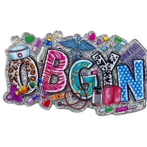 May include: A glittery badge with the letters OBGYN, featuring medical and baby-related icons. The letters have various patterns, including leopard print, zebra stripes, and polka dots. The badge includes a caduceus, baby bottle, and medical supplies.