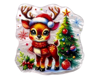 May include: A decorative acrylic piece featuring a cartoon reindeer with large eyes, wearing a red Santa hat and scarf. Beside the reindeer is a decorated Christmas tree with colorful ornaments, a star topper, holly berries, and snowflakes.