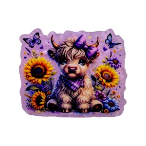 May include: A whimsical illustration of a Highland cow calf with a purple bow, scarf, and surrounded by sunflowers, butterflies, and other flowers. The artwork has a soft, colorful, and slightly glittery appearance, set against a lavender background.