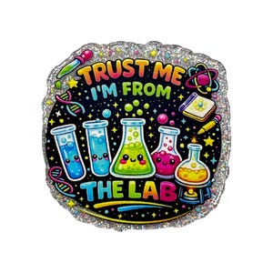May include: A circular glittery sticker featuring a black background with colorful science laboratory glassware including test tubes and flasks with smiling faces. The text reads TRUST ME I'M FROM THE LAB in bright yellow, green, and pink letters.