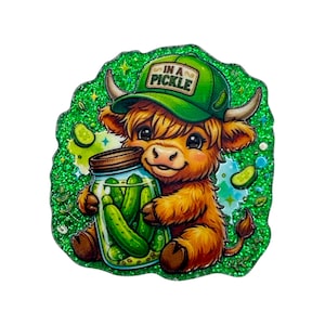 May include: A glittery green sticker featuring a fluffy brown Highland cow wearing a green baseball cap with the text IN A PICKLE. The cow is holding a glass jar filled with green pickles, surrounded by small pickle slices and sparkles.