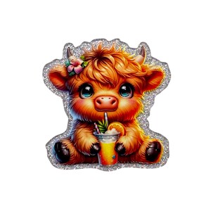 May include: A glittery sticker featuring a fluffy ginger highland cow with large dark eyes and small horns. The cow has a pink flower tucked behind one ear and is holding a clear plastic cup filled with a yellow drink, a pineapple slice, and a straw.