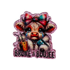 May include: A glittery pink cow-shaped pin with a plaid bow, holding a credit card and a drink. The cow has large, teary eyes and the text "BROKE & BOUJEE" is at the bottom. The pin is a cute and humorous accessory.