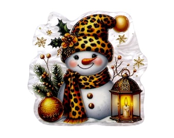 May include: A snowman ornament featuring a leopard print hat and scarf, a green holly sprig, a gold ornament ball, and a lit lantern. The snowman has a carrot nose, two brown buttons, and is surrounded by gold snowflake accents on a white background.