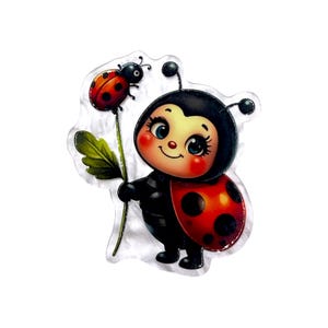 May include: A clear acrylic brooch featuring a cartoon ladybug character with a black head, red and black spotted wings, and large blue eyes. The character holds a green stem with a smaller ladybug perched on top against a transparent background.