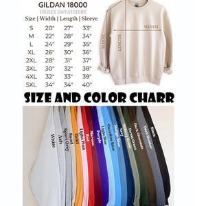 Puede incluir: Una sudadera unisex Gildan 18000 beige cuelga de una percha de madera. La imagen incluye una tabla de tallas con medidas en pulgadas y una tabla de colores con varios colores de sudaderas, incluyendo blanco, negro y marino.