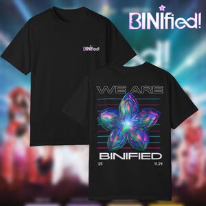 May include: Black t-shirts with the text "BINIfied!" on the front and back. The back of the shirt features a colorful flower graphic with the words "WE ARE" above and "BINIfied" below. The date "11.29" is also printed on the back.