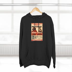 May include: Black hoodie with a vintage-style poster design. The poster features the text "WHO DA MASTER?" with images of two people and the names "SHO'NUFF" and "BRUCE LEROY". The hoodie is hanging on a wooden hanger.