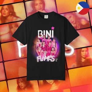 May include: Black t-shirt featuring the text "BINI" above a group photo of women in pink outfits, with the word "FLAMES" below. A pink star is above the word "BINI". The background is a collage of images.