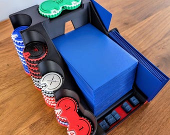 May include: A black and blue game card organiser with various coloured game pieces. The organiser has a section for cards, and slots for game tokens. The game pieces are red, white, blue, and green.