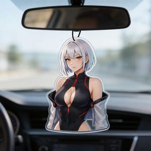 May include: Anime-style car air freshener featuring a female character with white hair and orange eyes. The character wears a black outfit with red accents and a light gray jacket. The air freshener hangs from a black string in front of a car's rearview mirror.