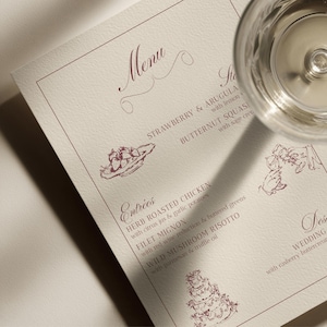 May include: A cream-colored paper menu with dark red text and line art illustrations. The menu features sections for Menu, Entrees, and Dessert, with drawings of strawberries, a tiered wedding cake, and clinking glasses.
