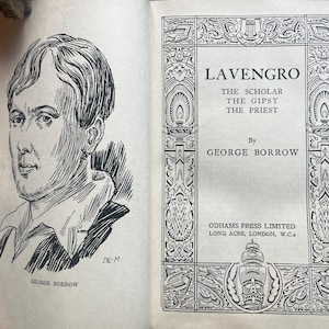 May include: An open book with a black and white illustration of a man on the left page and the title "Lavengro" on the right page. The book's author is George Borrow.