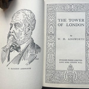 May include: An open book with a black and white illustration of a man with a beard and a bow tie. The book's title is "THE TOWER OF LONDON" by W. H. Ainsworth, published by Odhams Press Limited.