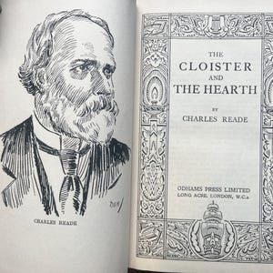 May include: An open book with a black and white illustration of a man with a beard and the title "The Cloister and the Hearth" by Charles Reade. The book's cover features decorative borders and the publisher's information.