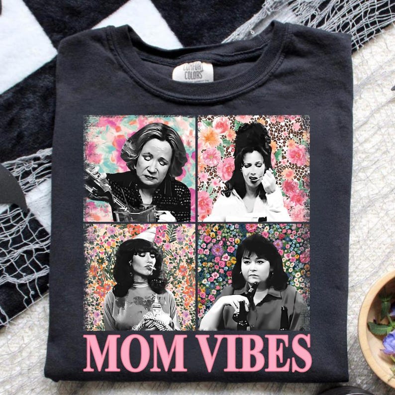 The image is a t-shirt with a collage of four black and white photographs of women, each with a different expression. The text "MOM VIBES" is printed below the collage.