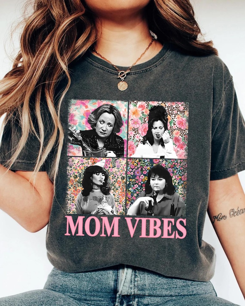 a woman wearing a black t-shirt with a graphic design of four photographs of a woman, along with the text "MOM VIBES" printed on the shirt.