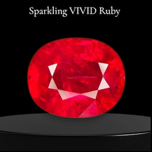 May include: A vivid red, oval-cut ruby gemstone with white facets, displayed on a black pedestal. The text "Sparkling VIVID Ruby" is above the gemstone.