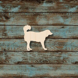 May include: A wooden cutout of a dog standing on a weathered, blue-painted wood background. The dog is light-colored, with a fluffy tail and a standing pose. The wood has a rustic, textured appearance.