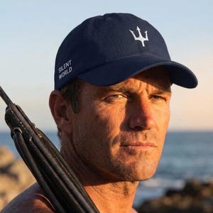 Puede incluir: Gorra de béisbol azul marino con un logotipo de tridente blanco y el texto "SILENT WORLD". La gorra es de estilo clásico, adecuada para actividades al aire libre. El sombrero está hecho de un material duradero.
