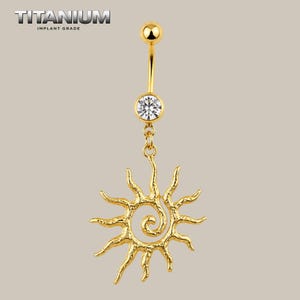 Puede incluir: Un piercing para ombligo de titanio de grado de implante en color dorado, con una barra curva, una bola superior, un cristal redondo transparente engastado en la parte inferior y un dije de sol con centro en espiral texturizado.