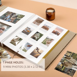 May include: Open photo album with nine mini photo slots, each holding photos. The album is open to a page with photos. The text on the image reads: 1 PAGE HOLDS: 9 MINI PHOTOS (3.38 x 2.12 IN). A small candle sits on the surface.