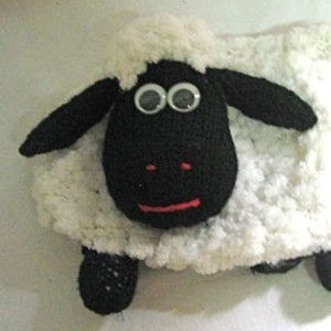 May include: A black and white crocheted sheep plush toy with large googly eyes. The sheep has a white fluffy body and black face, ears, and legs.