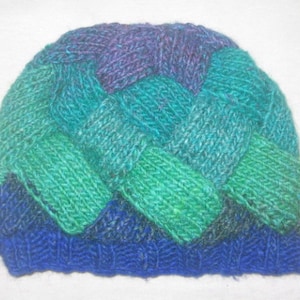 May include: A blue, green, and purple knitted hat with a braided pattern.