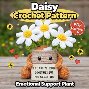 Puede incluir: Una planta de margaritas de ganchillo con pétalos blancos y centros amarillos, en una maceta beige con brazos y piernas. La planta sostiene un letrero que dice "LIFE CAN BE TOUGH SOMETIMES BUT BUT SO ARE YOU". El texto "Daisy Crochet Pattern" está en la parte superior.