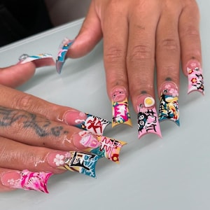 May include: Close-up of long, decorated fingernails. Each nail features a unique design with vibrant colours, including pink, blue, yellow, and white. The designs incorporate floral patterns, cartoon characters, and Japanese-inspired elements.