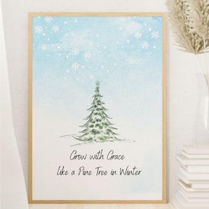 May include: Framed art print with a watercolour illustration of a green pine tree under a light blue sky with falling snowflakes. The artwork includes the text "Grow with Grace like a Pine Tree in Winter."