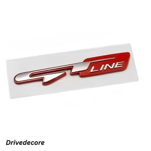 May include: A red and silver GT Line emblem. The emblem features a stylized "GT" design with the word "LINE" in white lettering. The emblem is on a white background.