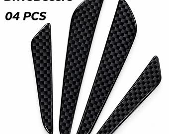 May include: Four black car door edge guards featuring a glossy carbon fiber checkered pattern. The set includes two longer and two shorter strips with curved ends. The text DriveDecore and 04 PCS are visible in the upper left corner of the image.