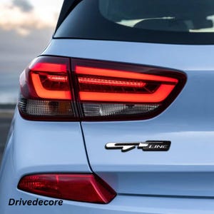 May include: Rear view of a light blue car with a red tail light and a black and silver "GT LINE" emblem. The text "Drivedecore" is visible at the bottom of the image.