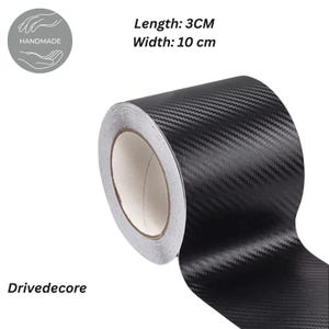 Può includere: Un rotolo di nastro in fibra di carbonio nero con un motivo strutturato. Il nastro è lungo 3 cm e largo 10 cm. L'immagine include il testo "Drivedecore" e un logo "fatto a mano".