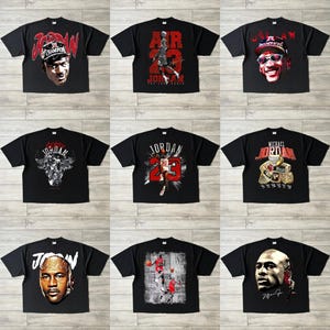 May include: Nine black t-shirts with different Michael Jordan graphics. Designs include portraits, action shots, and text such as "JORDAN" and "AIR 23". The shirts are displayed on a light-coloured surface.