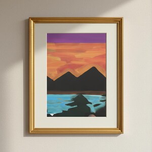 Puede incluir: Impresión artística de paisaje abstracto en un marco dorado. La obra presenta una silueta de cordillera sobre un cielo de atardecer con tonos naranja, morado y azul. El marco es rectangular y dorado.