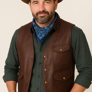 May include: A brown leather vest with two front pockets and brass-colored buttons. The vest is worn over a dark green button-down shirt, blue bandana, and brown hat. A brown leather belt is also visible.
