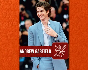 May include: A 2027 wall calendar featuring a photograph of Andrew Garfield wearing a light blue blazer and a white button-down shirt. The calendar includes the text Andrew Garfield and the year 2027 in a dark red rectangular graphic.