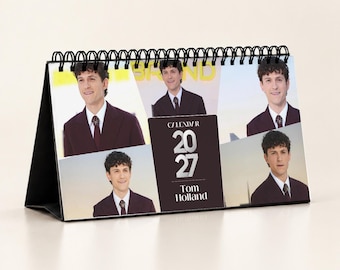 Könnte beinhalten: Ein Tischkalender für 2027 mit Tom Holland, gebunden mit einer schwarzen Spiralbindung. Der Kalender zeigt vier verschiedene Fotos des Schauspielers in einem dunklen Anzug mit Krawatte und den weißen Text "CALENDAR 2027 TOM HOLLAND".