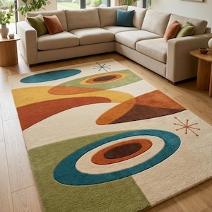 Könnte beinhalten: Ein großer, rechteckiger Teppich mit Retro-Design. Der Teppich hat einen cremefarbenen Hintergrund mit bunten geometrischen Formen in Grün, Blau, Orange und Gelb. Der Teppich liegt auf einem Holzboden in einem Wohnzimmer.