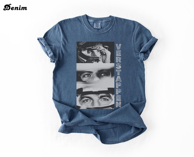 May include: Denim blue t-shirt featuring a black and white graphic of a person's face and the word "VERSTAPPEN" printed vertically. The word "Denim" is printed in the upper left corner.