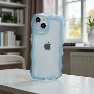 以下が含まれることがあります： ライトブルーの波状の縁取りが付いた透明なiPhoneケース。ケースの背面は透明で、Appleのロゴが見えます。ケースには2つのカメラレンズとフラッシュがあります。ケースは白い表面にあります。