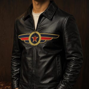 May include: A black leather jacket featuring a full-length front zipper, a classic collar, and a prominent embroidered emblem on the chest. The emblem displays a central red star inside a gold circle, flanked by stylized blue and red wings.