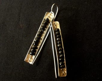 May include: Silver earrings with black beads and a hammered metal design.