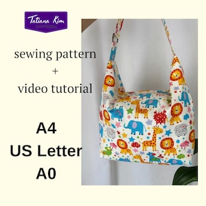 Może przedstawiać: Biała torba na ramię z kolorowym zwierzęcym nadrukiem, w tym lwy, żyrafy i słonie. Torba ma pasujący pasek i tekst "sewing pattern + video tutorial". Zaprojektowana dla formatów A4, US Letter i A0.