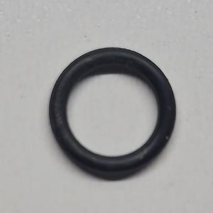 May include: A black rubber O-ring, circular in shape, sits against a white background. The O-ring is a solid, seamless loop, likely used for sealing or as a gasket in mechanical applications. The rubber appears to be smooth and flexible.