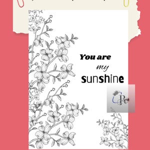 Può includere: Una stampa bianca con illustrazioni floreali nere e la scritta "You are my sunshine". La stampa ha uno sfondo rosa con l'URL del negozio Etsy e il nome del negozio. Una graffetta rossa e gialla in alto.